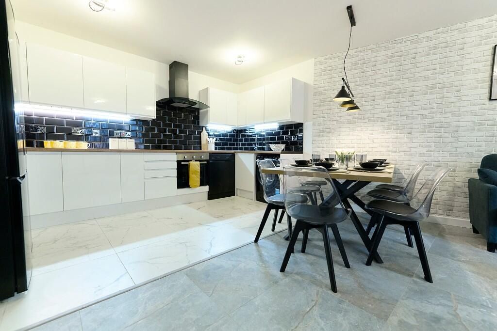 Property photo 3 of 13 A Modern, Sleek Kitchen And Dining Area Featuring ...