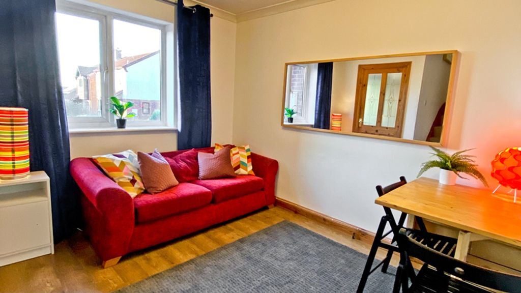 Property photo 2 of 6 This Inviting Living Room Features A Cozy Red Sofa...