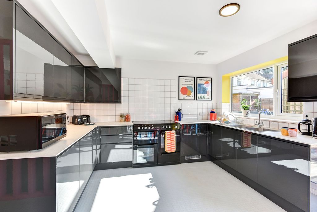 Property photo 2 of 5 Bright And Modern Kitchen Featuring Sleek Black Ca...