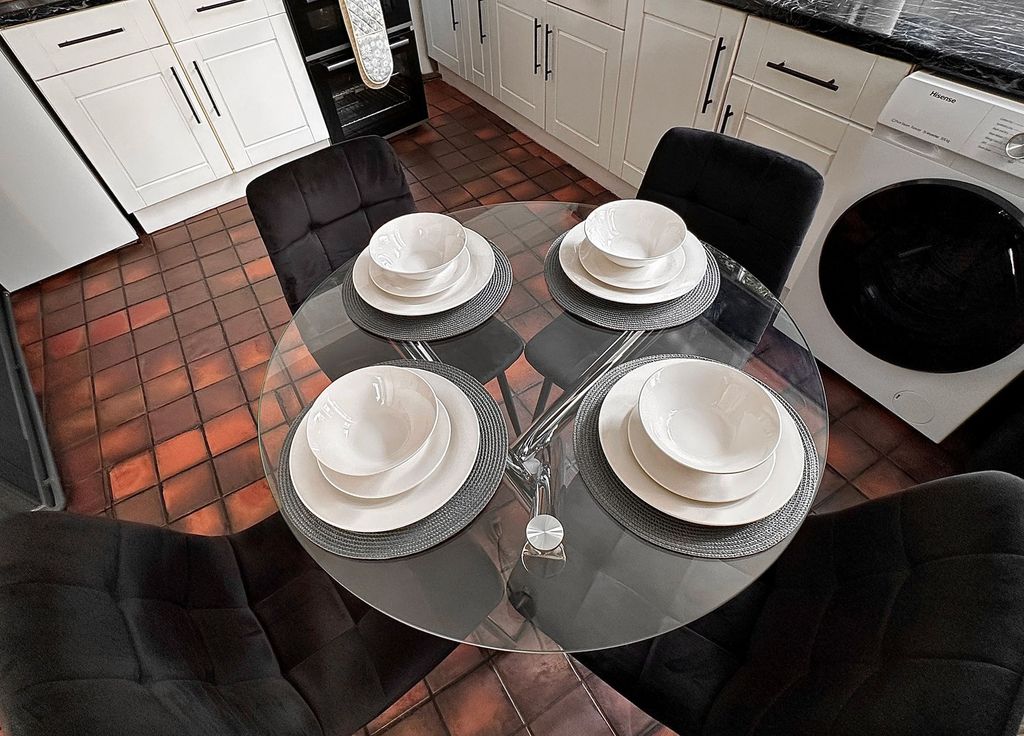 Property photo 3 of 11 A Modern Kitchen Featuring A Sleek Glass Dining Ta...