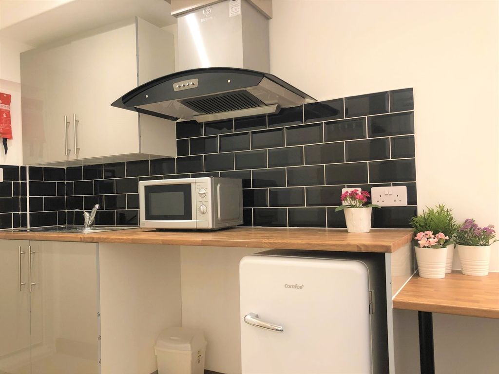 Property photo 3 of 8 A Modern Kitchen Featuring Sleek Black Tiled Backs...