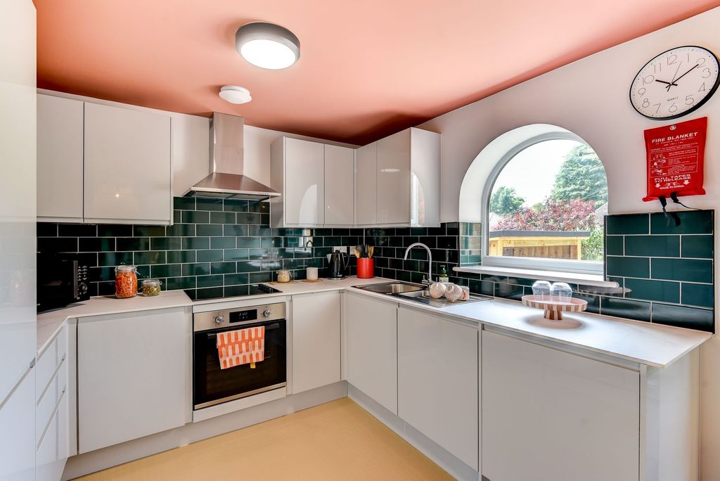 Property photo 3 of 6 Bright And Modern Kitchen Featuring Sleek White Ca...