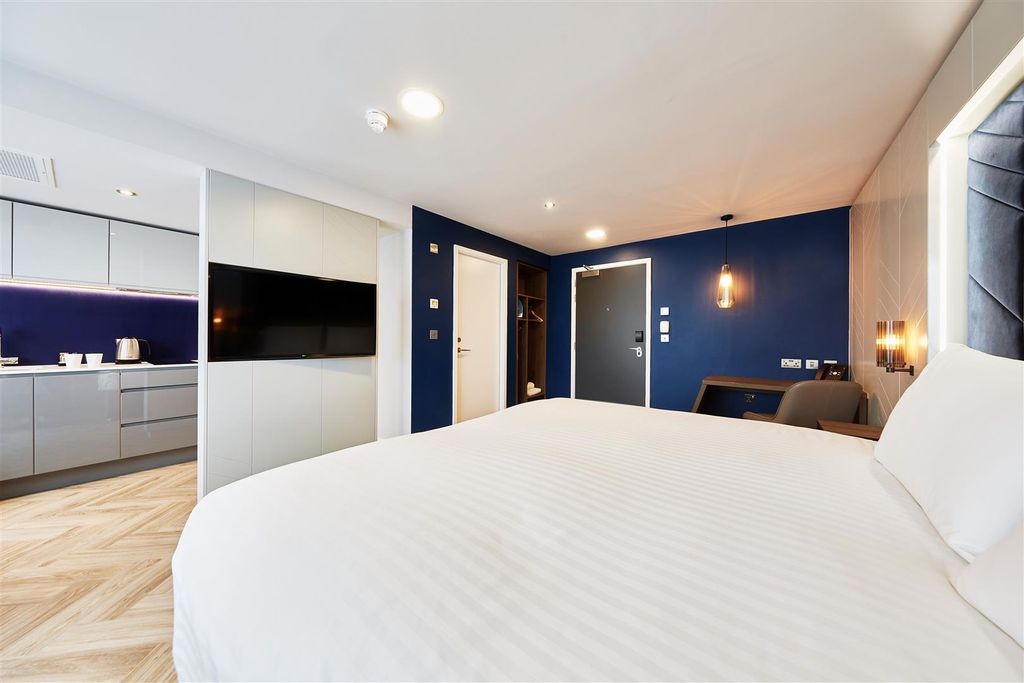Property photo 3 of 5 Modern, Well-Lit Bedroom With A Comfortable White-...