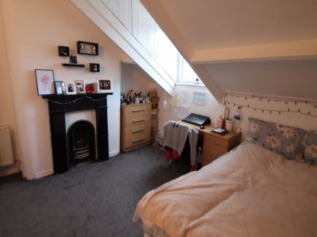 Property photo 3 of 18 A Cozy Bedroom With A Sloped Ceiling, Featuring A ...