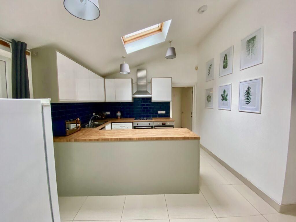 Property photo 2 of 8 Bright Modern Kitchen With White Cabinetry, A Wood...