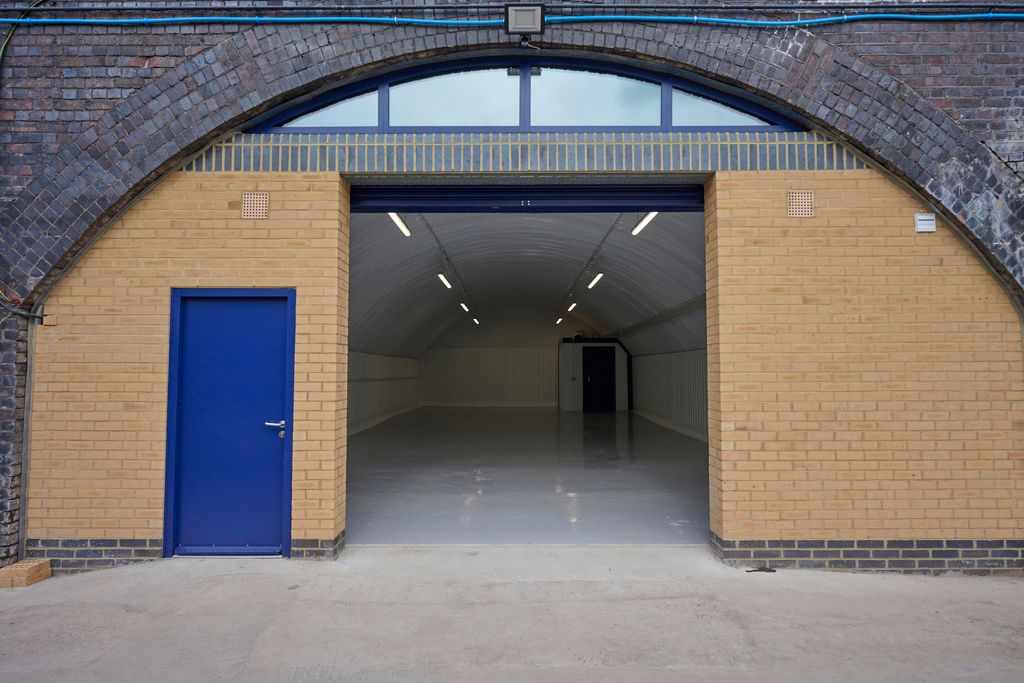 Property photo 2 of 8 The Front Of An Arch, With High Level Glazing, An Open Electric Roller Shutter Entrance Big Enough For Vehicle Access, And A Pedestrian Door.