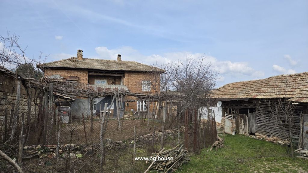 Property photo 1 of 94 View Of A Two-Storey Brick House With A Tiled Roof, Wooden Outbuildings, And A Fenced Garden Area With Leafless Trees And Vines
