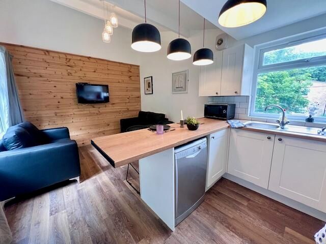 Property photo 2 of 9 Bright And Modern Kitchen Featuring Sleek White Ca...