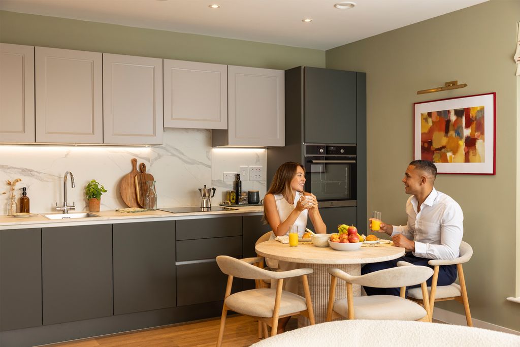 Property photo 2 of 6 Couple Sat At The Dining Table Next To The Kitchen Having Breakfast Together