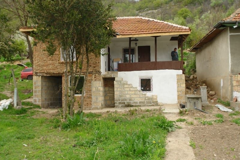 Property photo 1 of 54 Front View Of A Two-Storey Rural Bulgarian House Featuring A Wooden Porch, Stone Stairs, And A Tiled Roof.