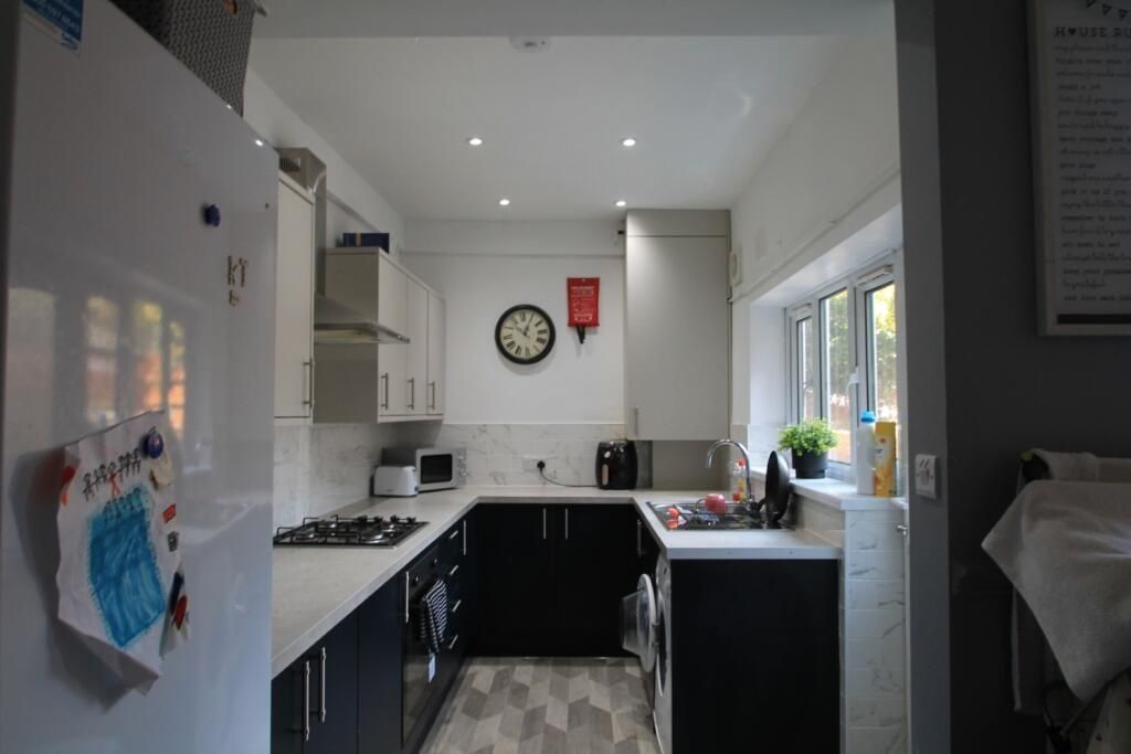 Property photo 2 of 7 Bright And Modern Kitchen Featuring Sleek Black An...