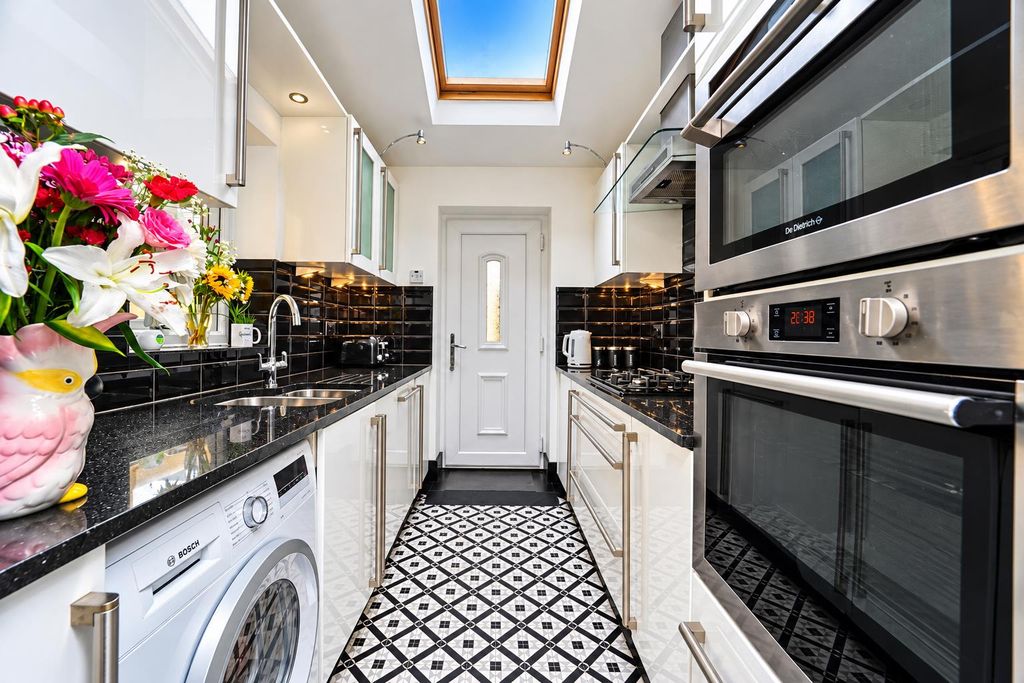 Property photo 3 of 16 Bright Galley Kitchen With Skylight And Floral Vas