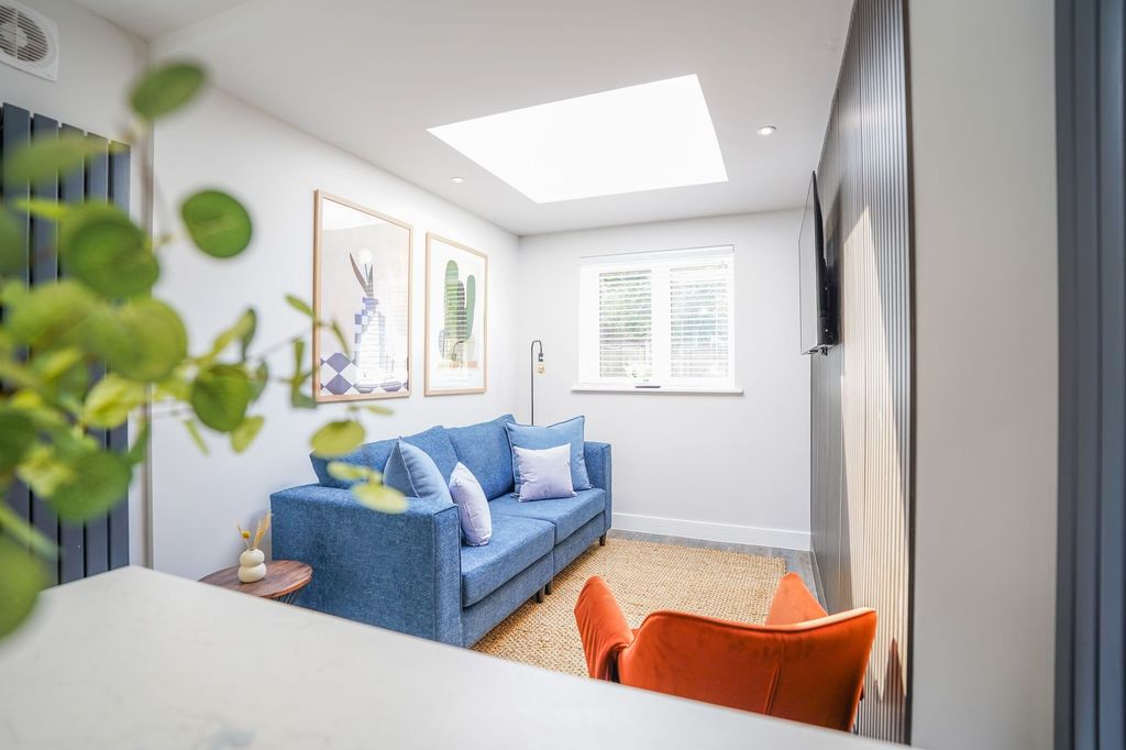 Property photo 1 of 15 Bright And Modern Living Room Featuring A Cozy Blu...