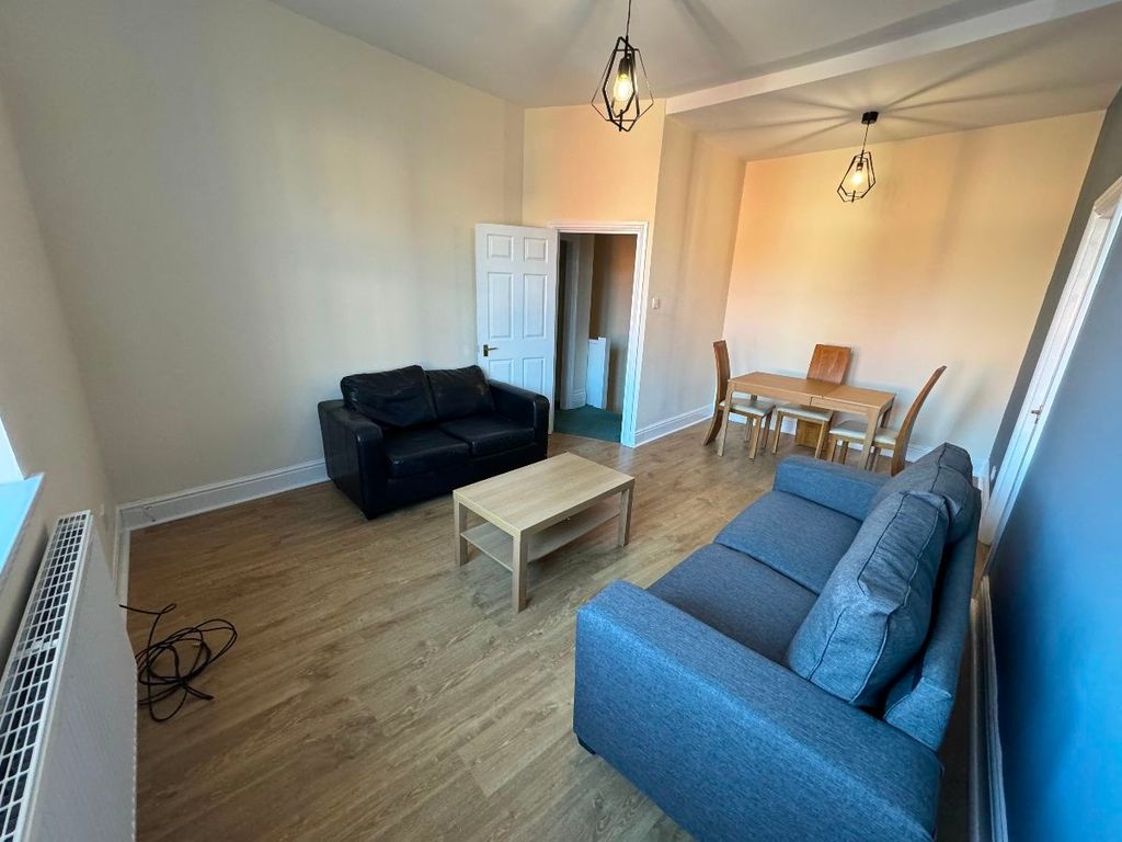 Property photo 1 of 12 A Bright And Welcoming Living Room Featuring A Dar...