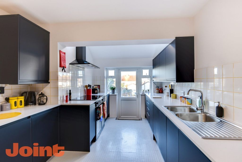 Property photo 2 of 6 Bright, Modern Galley Kitchen With Sleek Dark Cabi...