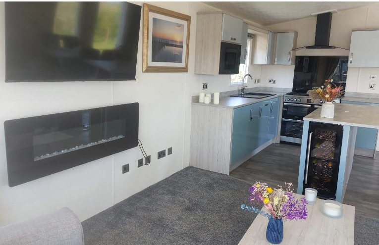 Property photo 3 of 12 Open Plan Lounge And Kitchen With Feature Fireplace And Modern Appliances