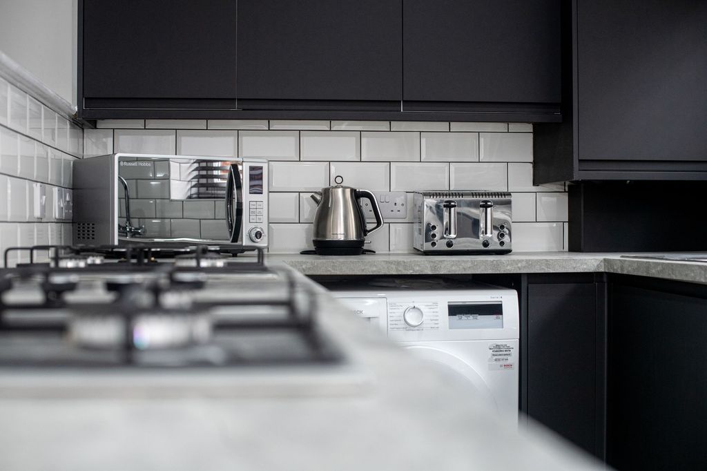 Property photo 1 of 9 Modern Kitchen With Sleek Black Cabinets, A Microw...