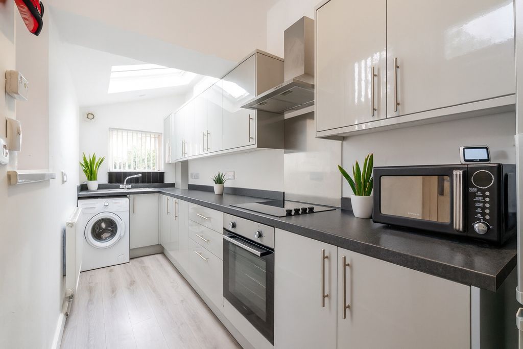 Property photo 2 of 7 Modern, Bright Kitchen Featuring Sleek White Cabin...