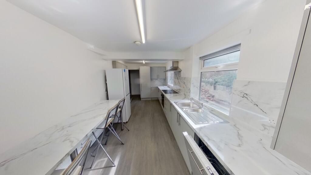 Property photo 3 of 11 Bright, Modern Galley Kitchen Featuring Sleek Whit...