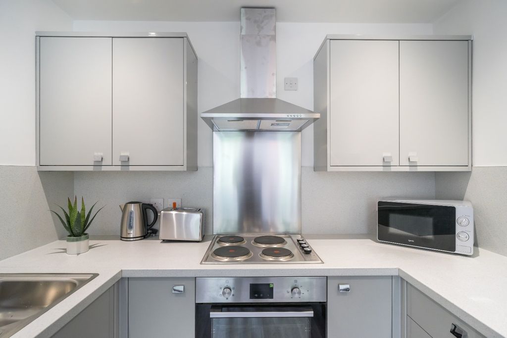 Property photo 3 of 15 A Modern Kitchen Featuring Sleek Cabinetry, Stainl...