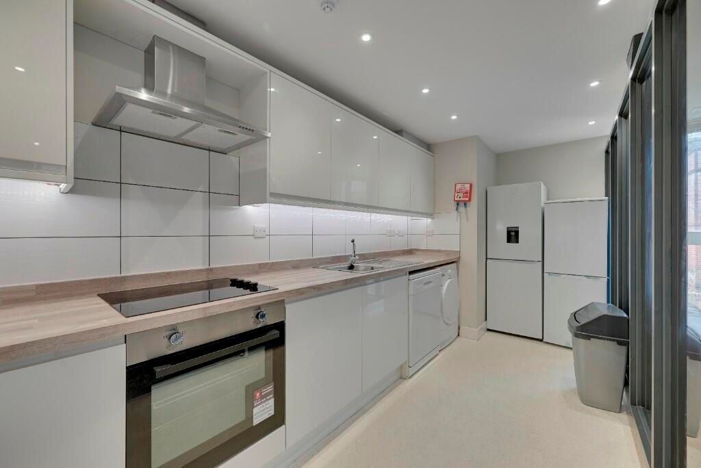 Property photo 2 of 16 A Modern Kitchen Featuring Sleek White Cabinetry, ...