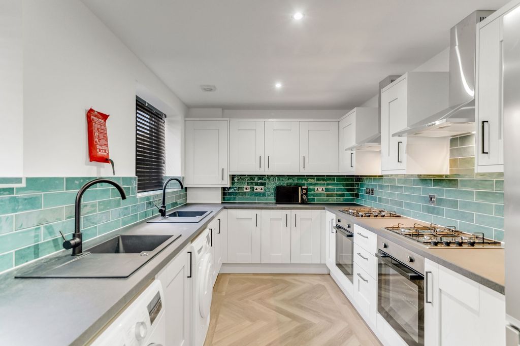 Property photo 3 of 5 Modern Kitchen Featuring White Cabinetry, A Sleek ...