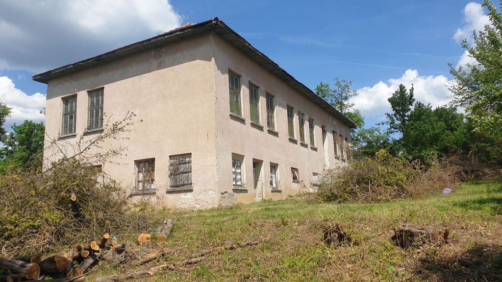 Property photo 2 of 26 Side Perspective Of The Old School Building With Barred Windows And Trimmed Vegetation In The Yard