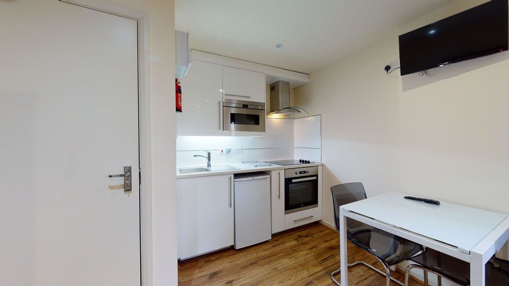 Property photo 3 of 8 A Modern, Compact Kitchen Featuring White Cabinetr...
