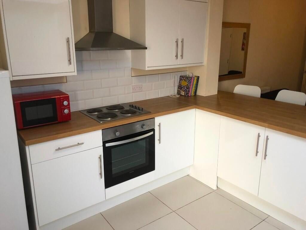 Property photo 3 of 12 A Modern Kitchen Featuring White Cabinetry, A Buil...
