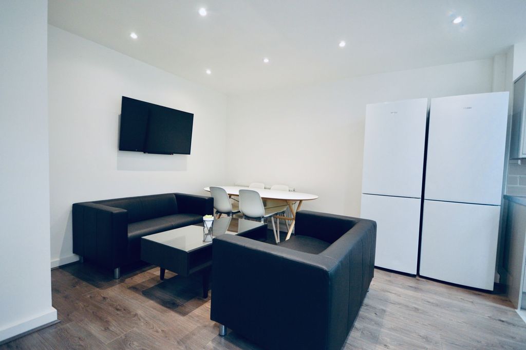 Property photo 2 of 9 A Modern, Well-Lit Living Room Featuring Two Black...