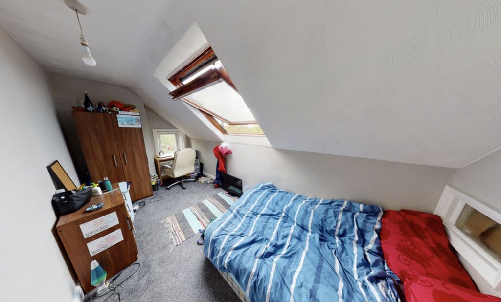 Property photo 3 of 9 A Cozy Bedroom With A Sloped Ceiling, Featuring A ...