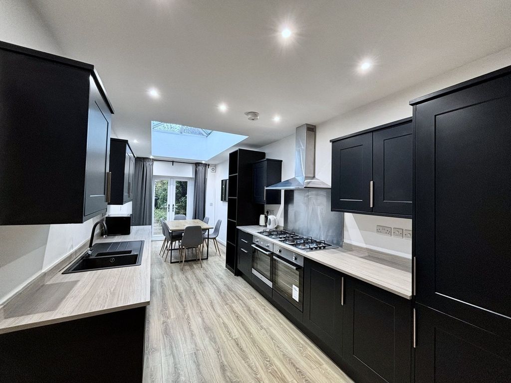 Property photo 1 of 13 A Modern And Spacious Kitchen Featuring Sleek Blac...