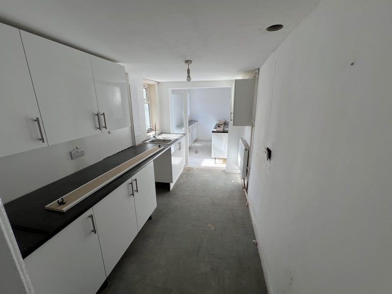 Property photo 3 of 4 Bright Kitchen Featuring White Cabinetry And Black...