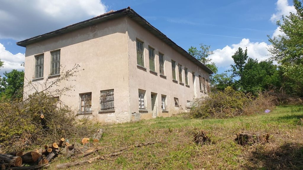Property photo 1 of 26 View Of The Two-Storey Old School Building With Barred Windows And A Grassy Yard With Trimmed Bushes
