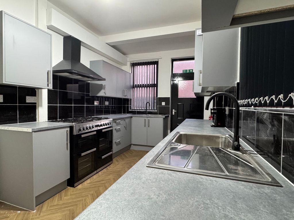 Property photo 3 of 10 Bright And Modern Kitchen Featuring Sleek Grey Cab...
