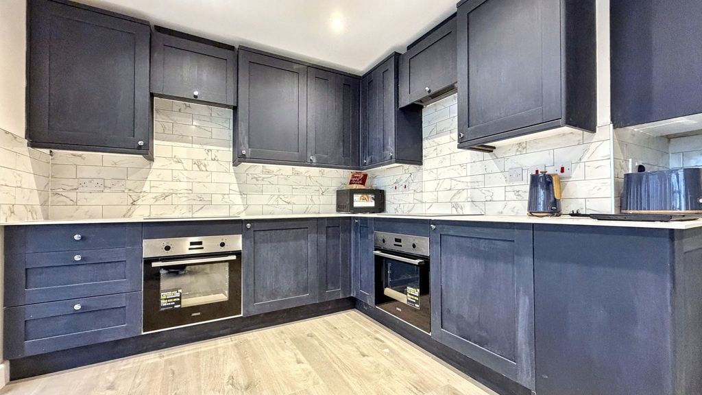 Property photo 3 of 15 Modern L-Shaped Kitchen With Deep Blue Cabinetry, ...