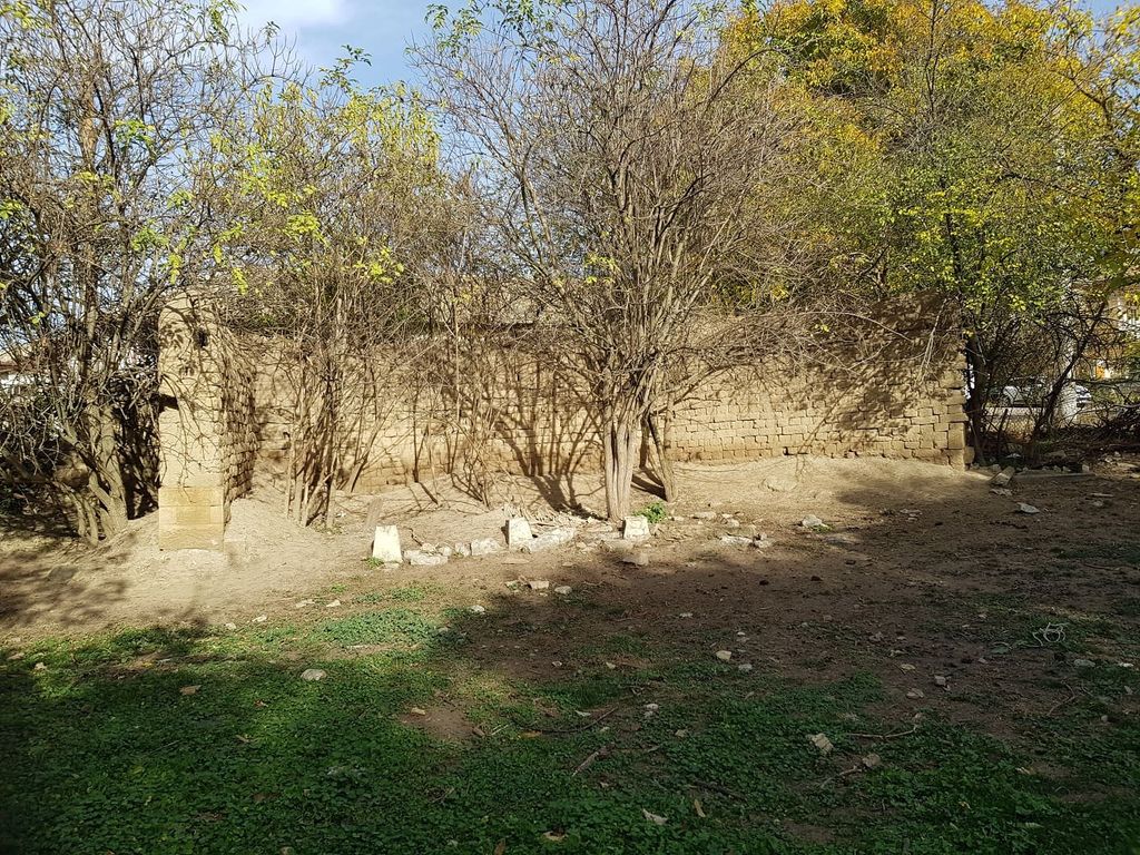 Property photo 2 of 10 A Ruined Stone Wall Partially Covered By Leafless Trees And Surrounded By Green Grass