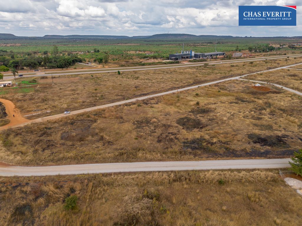 Property photo 3 of 10 Aerial View Of A Dry, Grassy Landscape With A Modern Building Along A Highway And A Chas Everritt Logo In The Upper Right Corner.