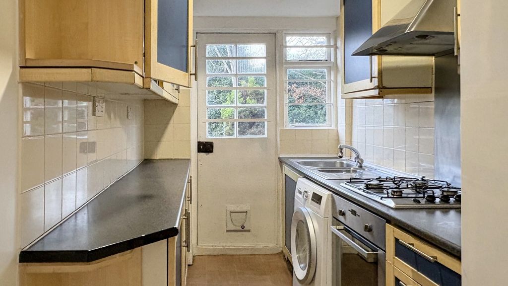 Property photo 3 of 15 Neat Galley Kitchen With Light Wood Cabinetry, Bla...