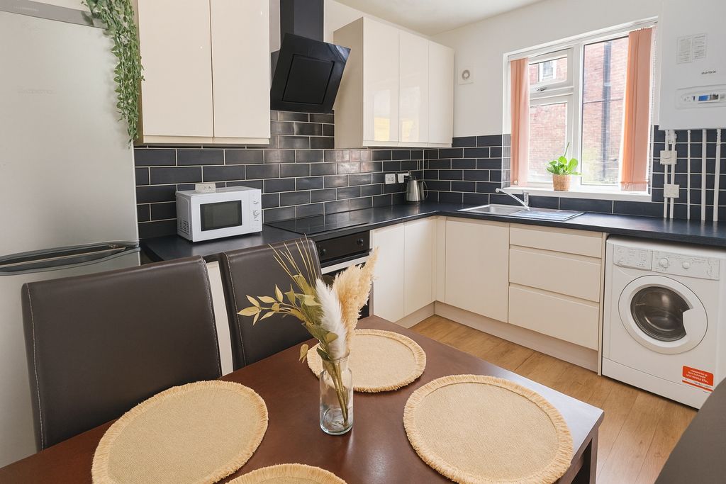 Property photo 1 of 8 Bright And Modern Kitchen Featuring Sleek Black An...