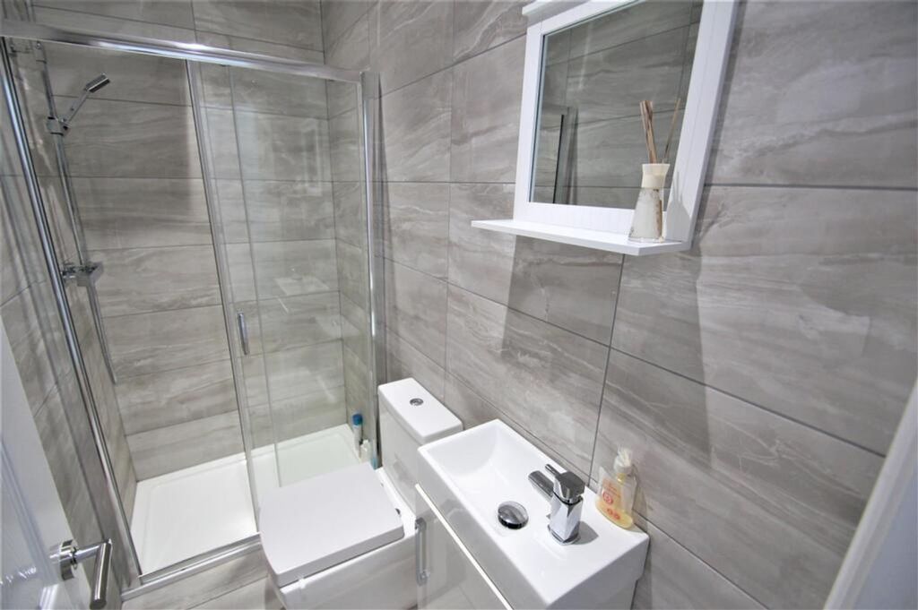 Property photo 2 of 8 This Modern Bathroom Features Sleek Gray Tiles, A ...