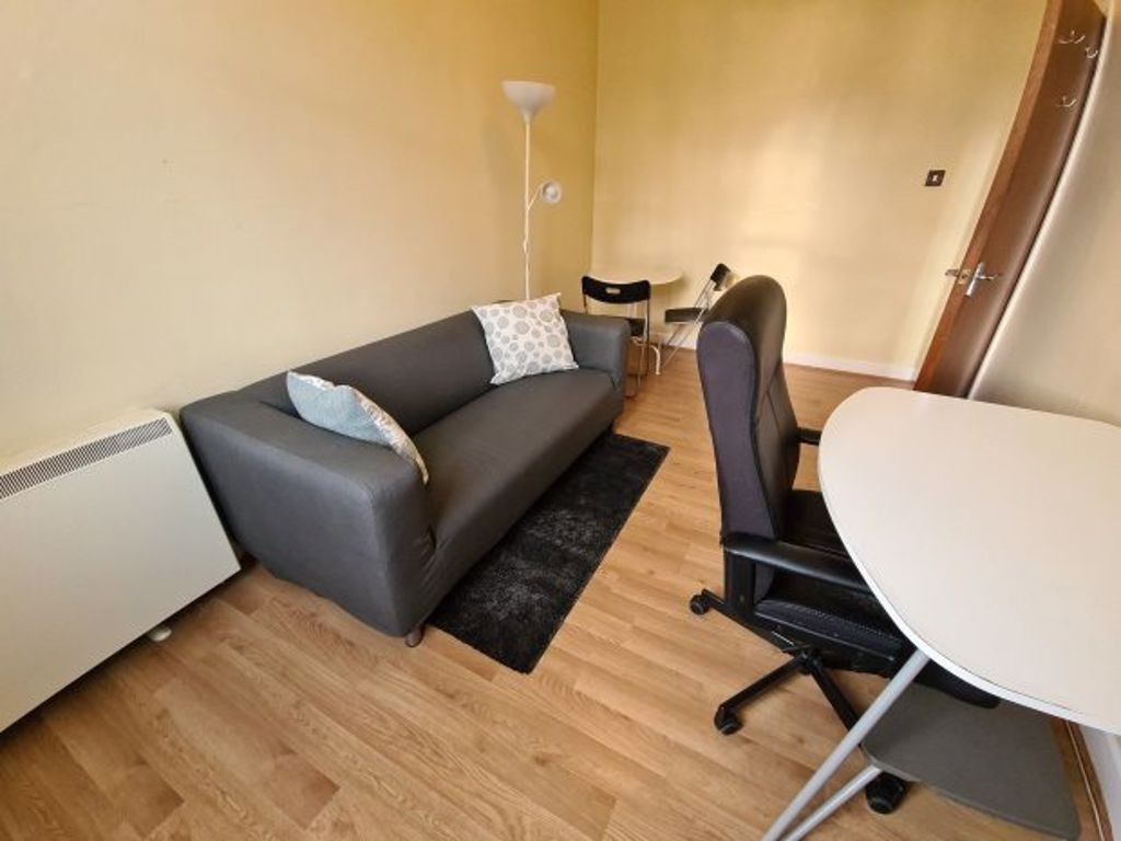 Property photo 3 of 5 A Cozy Living Area Featuring A Comfortable Dark Gr...