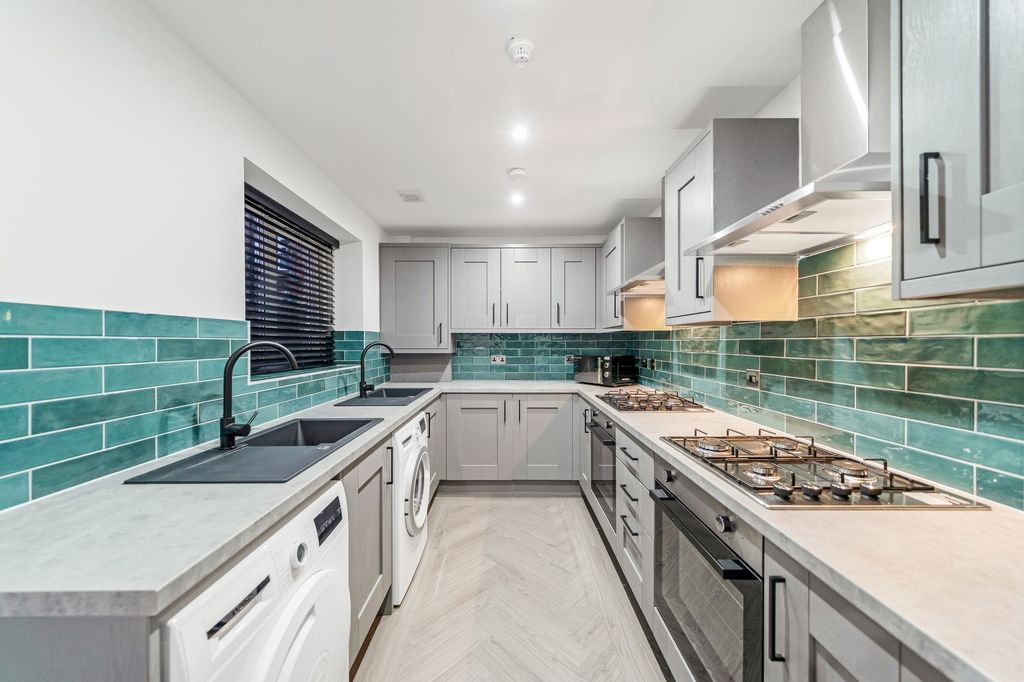 Property photo 2 of 4 Modern Kitchen Featuring Sleek Grey Cabinetry, Vib...