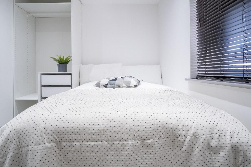 Property photo 1 of 13 A Bright And Neatly Made Bedroom Featuring A Comfo...