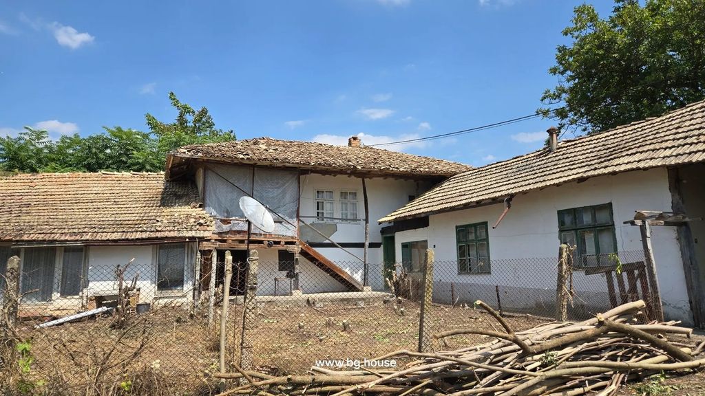 Property photo 3 of 75 Another View Of The Traditional Bulgarian House With Annexes, Tiled Roofs, Wooden Stairs, Fenced Yard With Dry Branches And Sparse Vegetation Under A Clear Blue Sky.