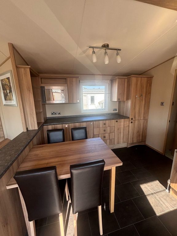 Property photo 2 of 12 Dining Area And Extensive Kitchen Storage Inside The Holiday Caravan
