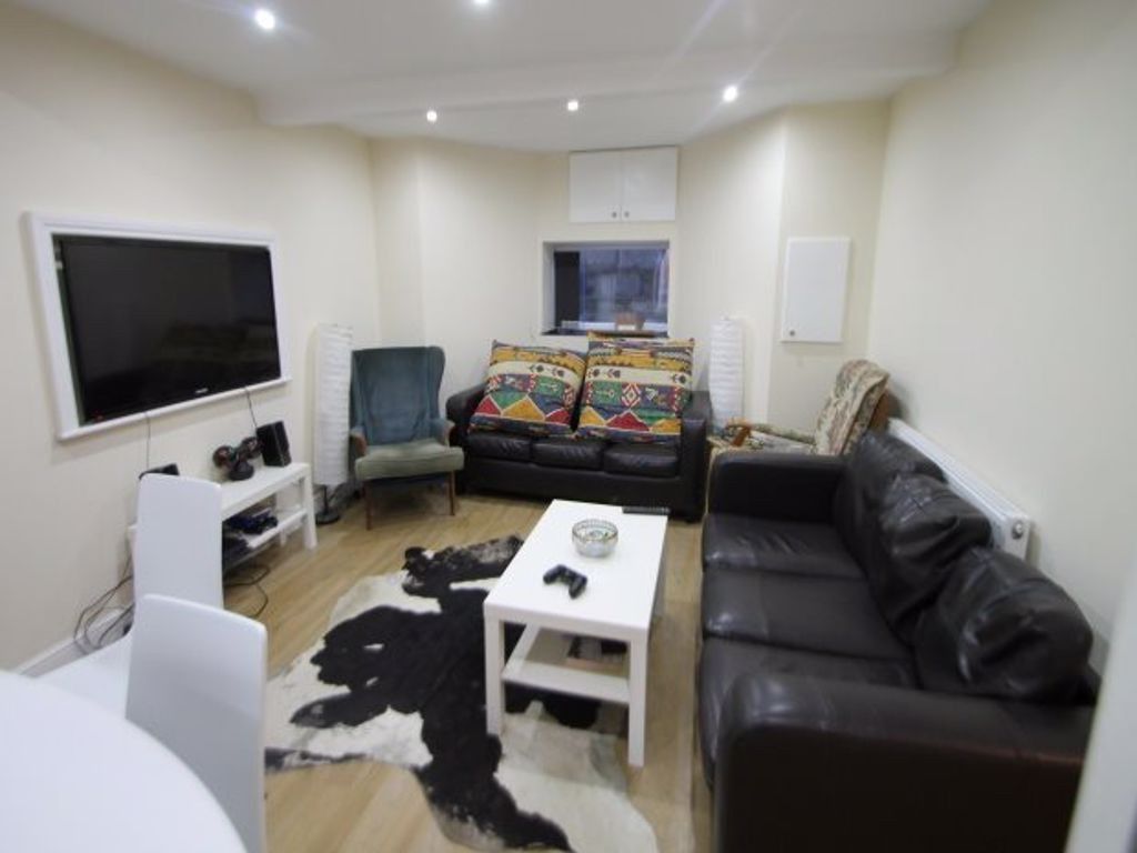 Property photo 1 of 12 A Cozy And Well-Lit Living Room Featuring Comforta...