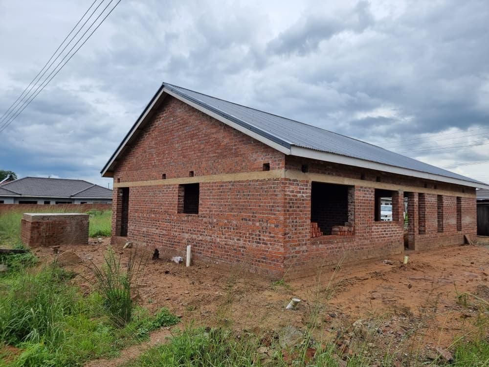 Property photo 3 of 12 Under-Construction Brick House With A Metal Roof And Open Window/Door Frames On A Dirt Yard At A Construction Site