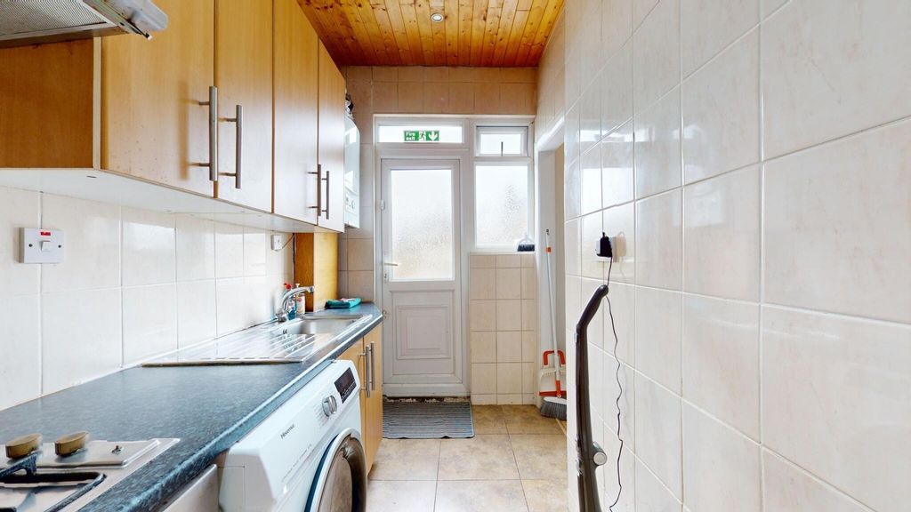 Property photo 3 of 7 Bright Galley Kitchen With Warm Wood Cabinetry, Ti...