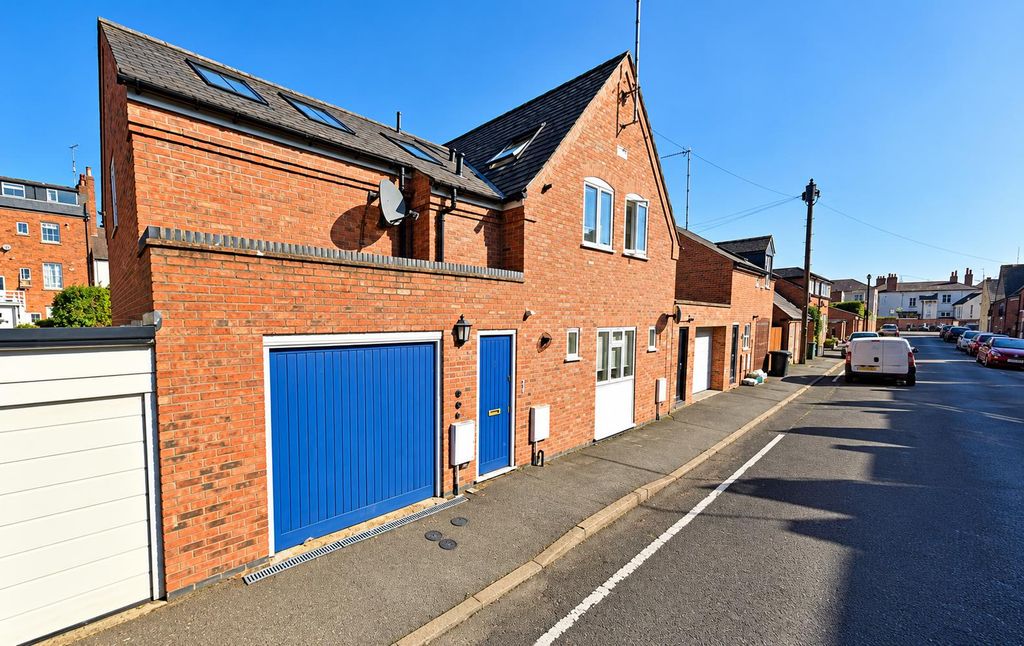 Property photo 1 of 6 Sunny Brick Townhouses And Blue Garage Doors.Png